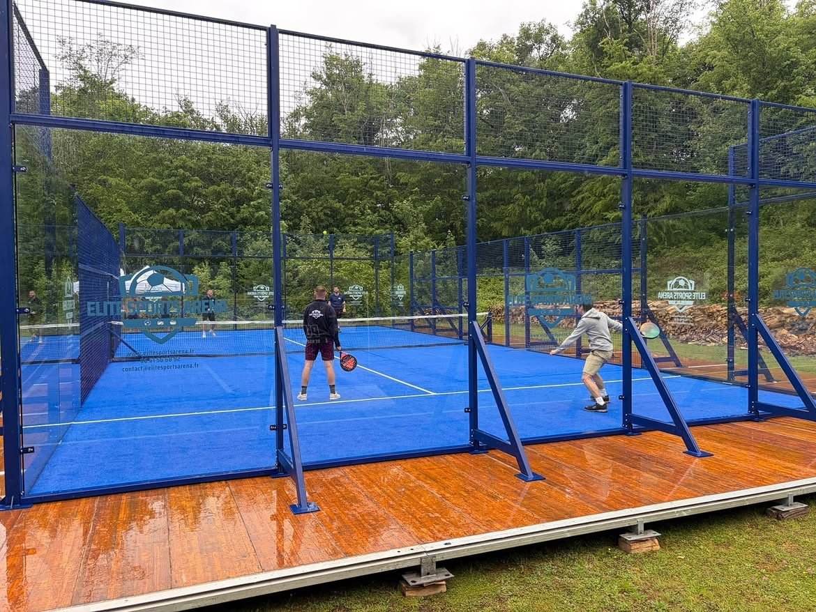 Premiers échanges sur le terrain de padel éphémère, gazon bleu et plancher bois